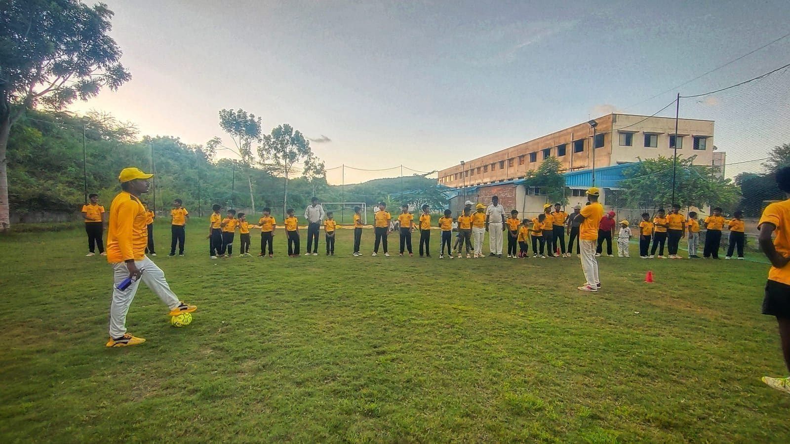 Coach leading a large group of players through standing exercises