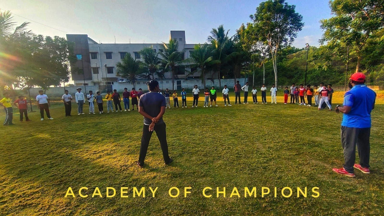 Coach addressing players gathered in a wide circle on the field