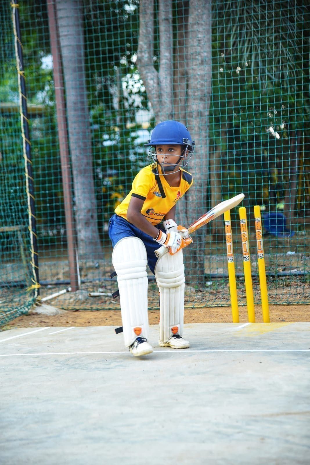 Junior batter playing a low defensive shot in the nets
