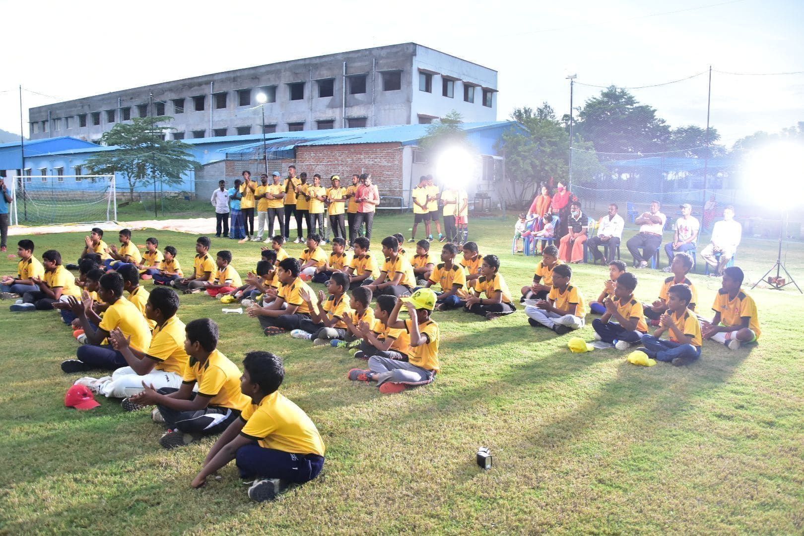 Academy juniors seated on the grass during an evening gathering