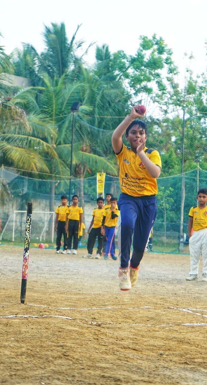 Young bowler raising both arms during a bowling drill