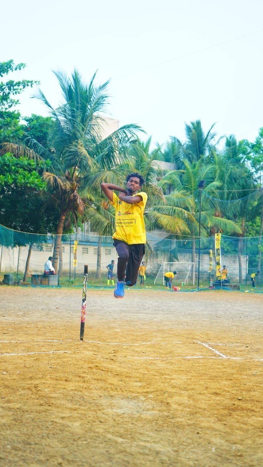 Young cricketer moving into a bowling action on the practice field
