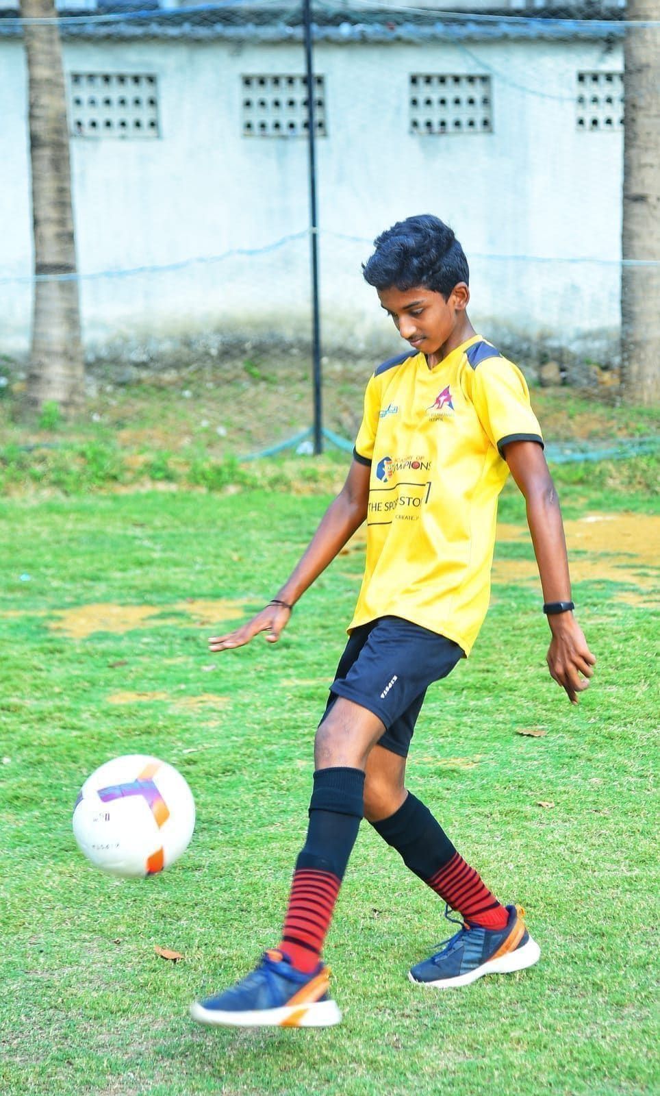 Young player keeping a football in the air with a raised foot