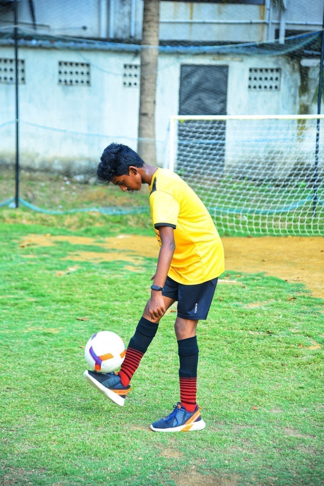 Young player lifting a football with one foot