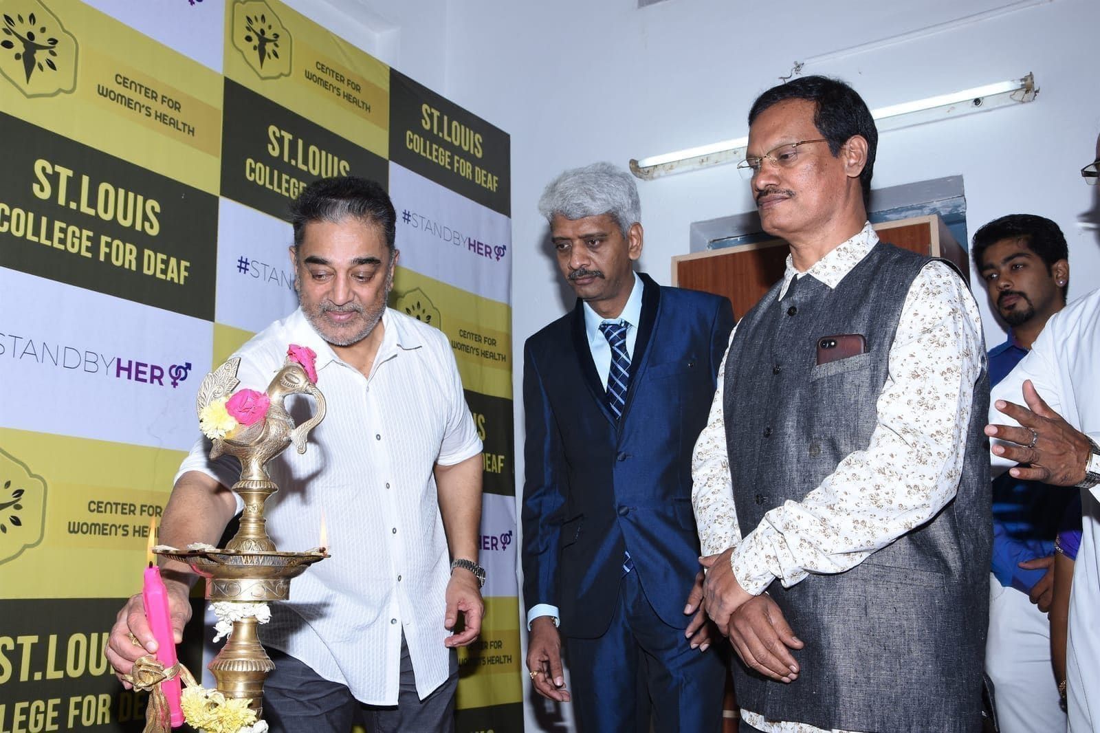 Guests lighting a ceremonial lamp at a community event