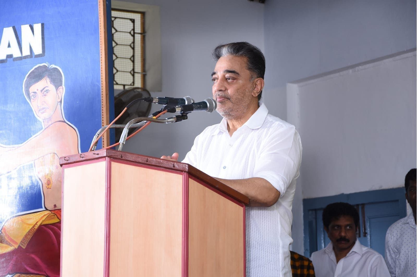 Guest in a white shirt speaking at a podium