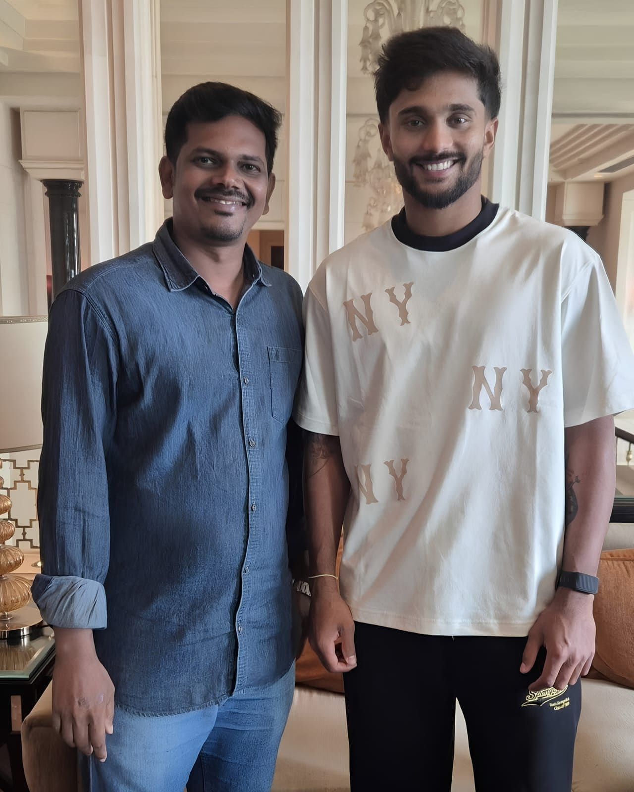 Two guests posing together in front of lounge curtains