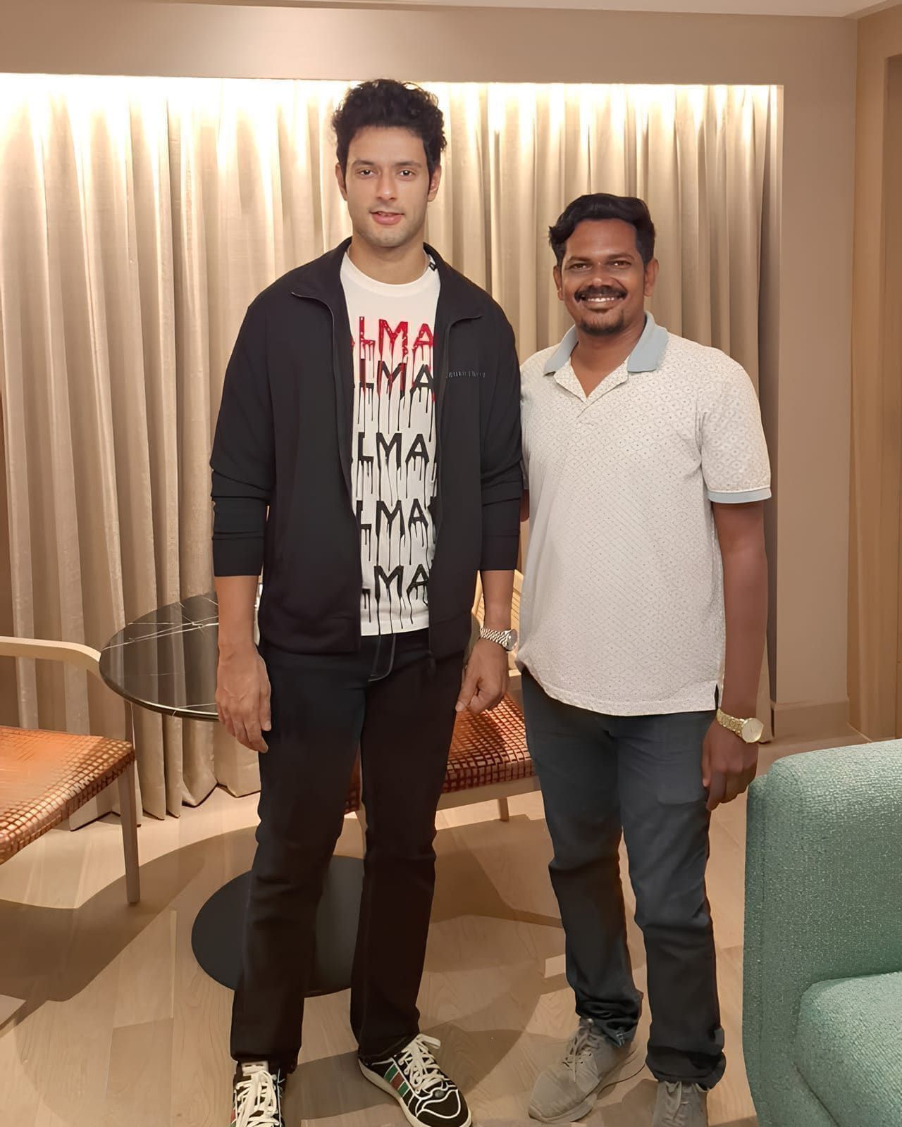 Two guests posing together at an indoor evening gathering
