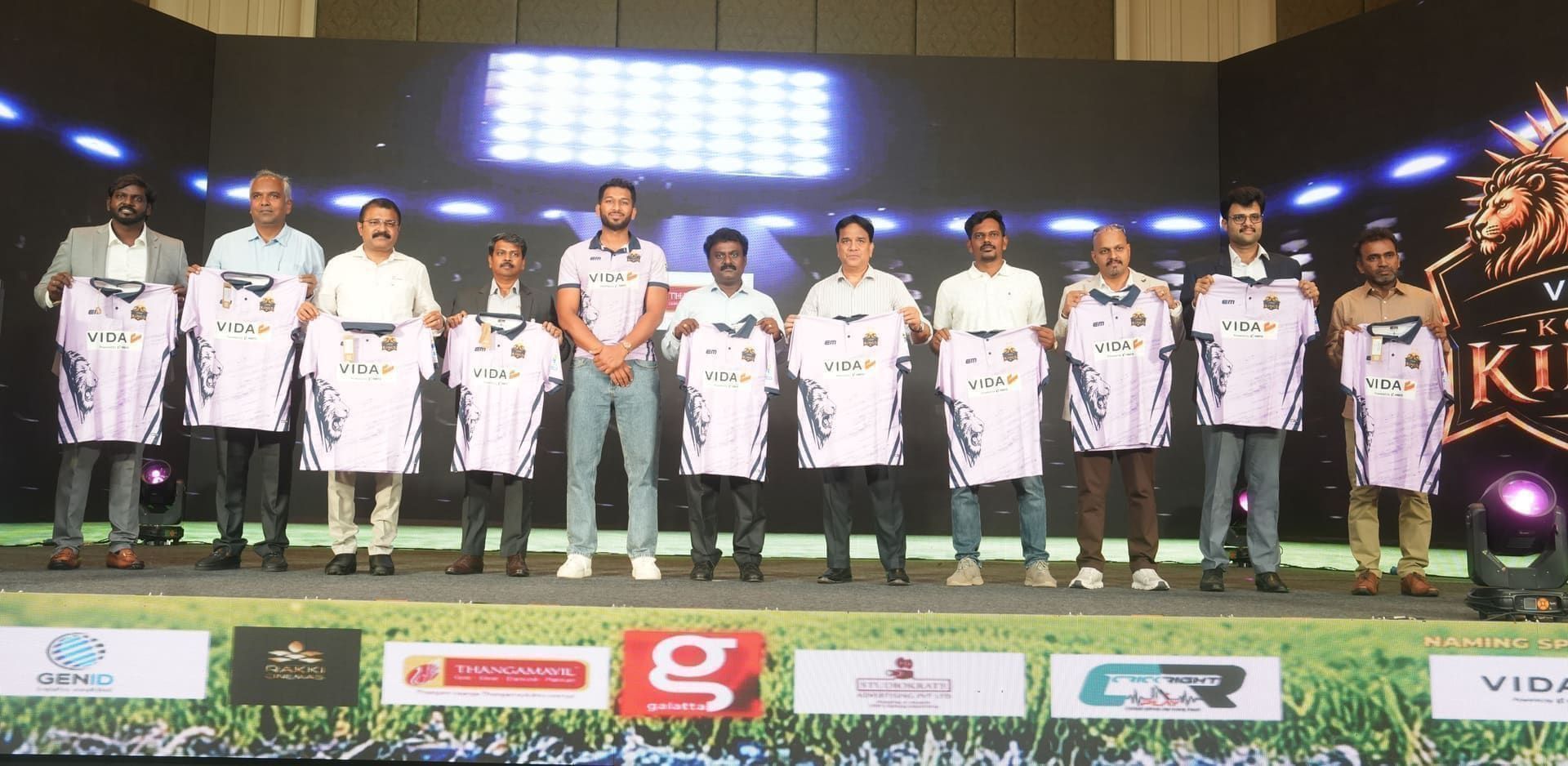 Franchise leadership on stage holding up new team jerseys
