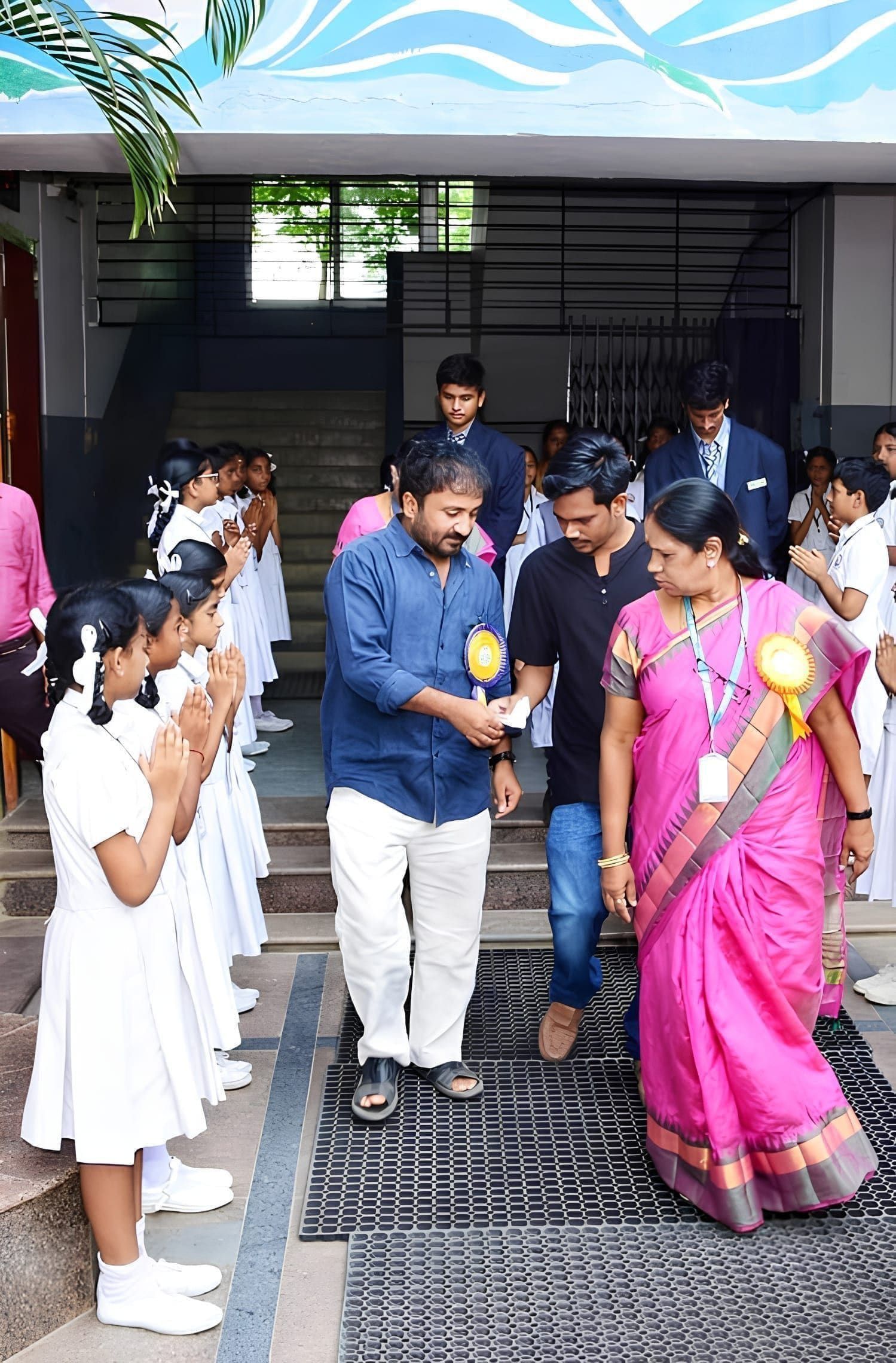 Guests walking through a school entrance with welcoming staff