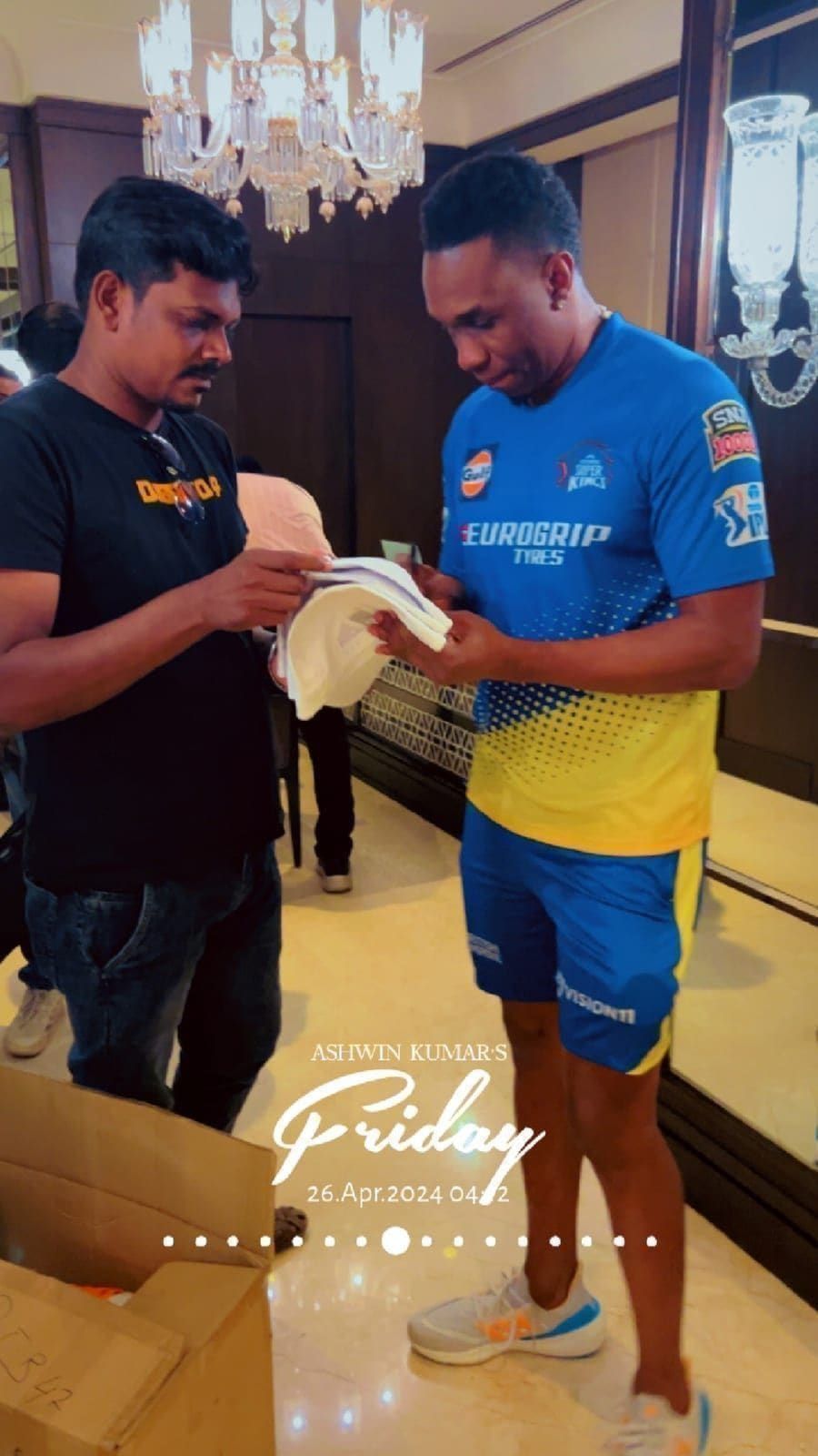 Cricket player in blue and yellow training kit signing a cap