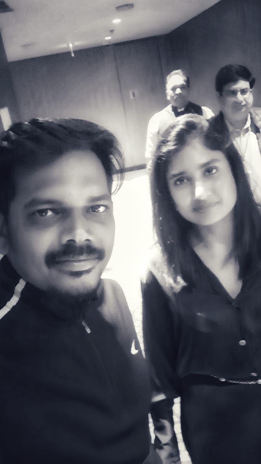 Guests posing for a black-and-white selfie at an indoor gathering