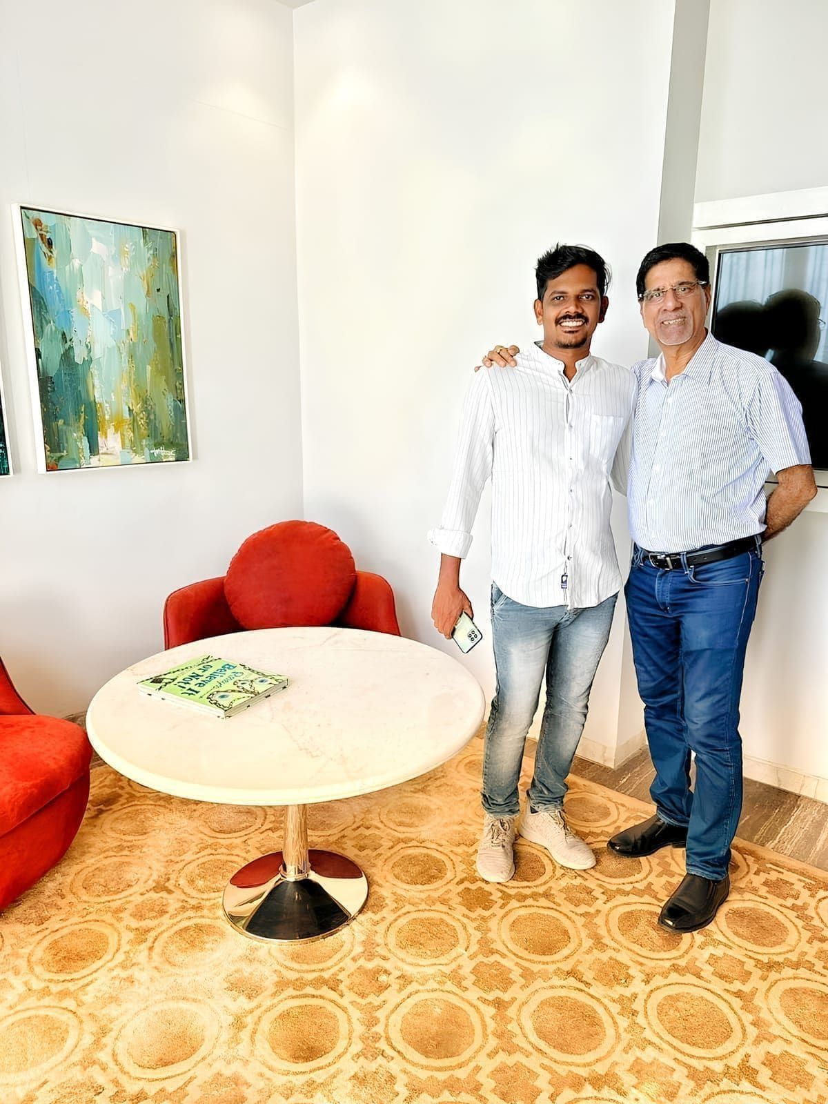 Two delegates posing beside a table in a hotel lounge