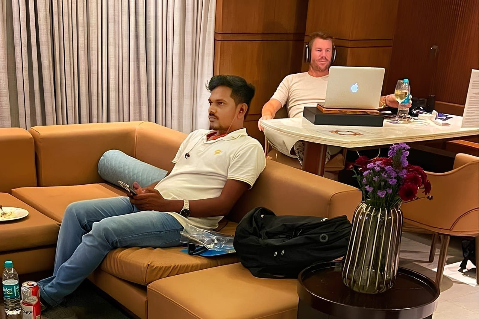 Guests seated in a lounge with a laptop on a nearby table