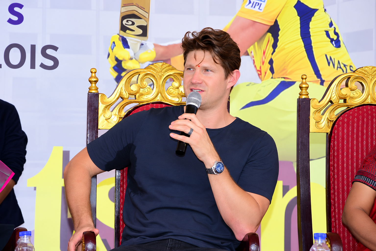 Guest speaker holding a microphone at a cricket event